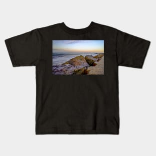 Close up of rocks and boulders protecting the cliffs on the Norfolk coast Kids T-Shirt